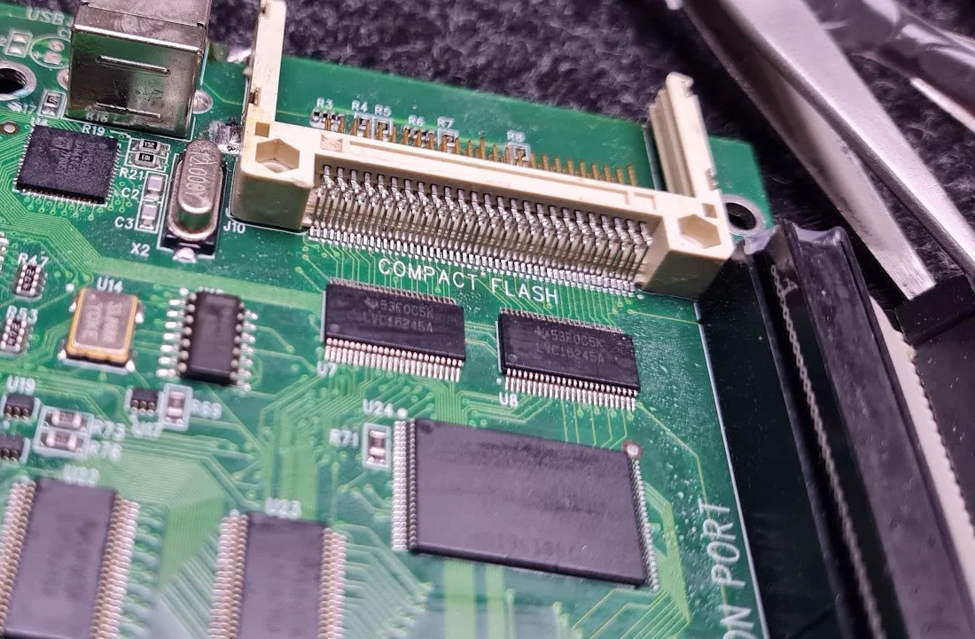 Detalle de una placa electrónica con circuitos integrados y un conector CompactFlash